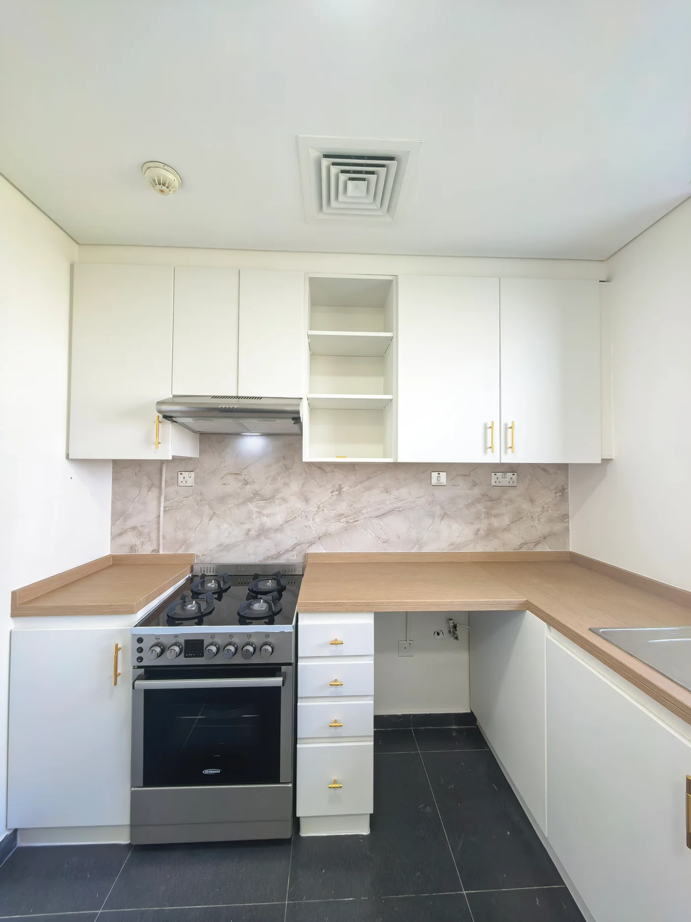 Wood finish countertop vinyl wrap with white cabinets Dubai kitchen