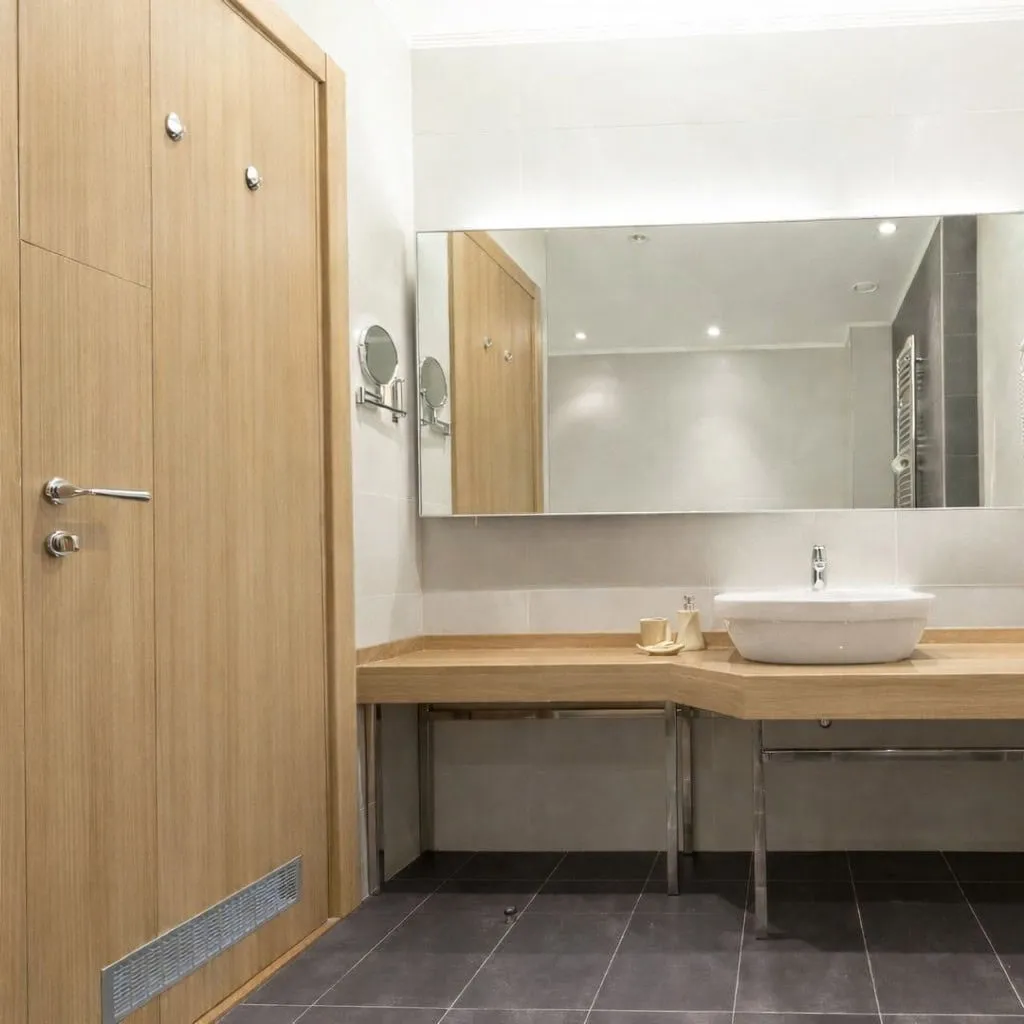 Bathroom door wrapped in light wood vinyl Dubai